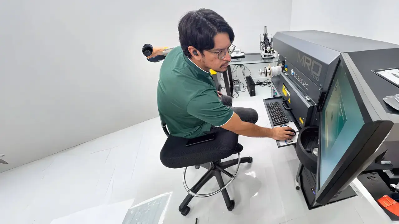 A man sitting in front of an aviation cable marking machine.